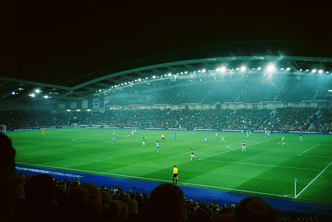 Gece ışıkları altında futbol stadyumu ve maç atmosferi