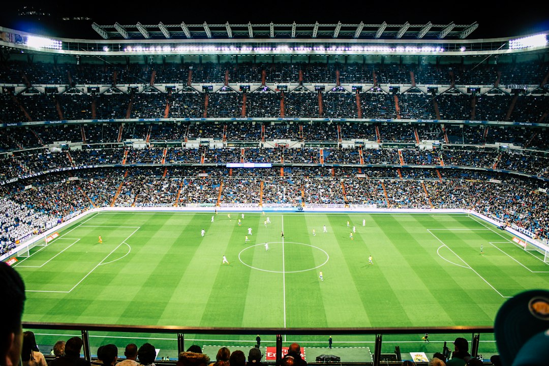 Gece ışıkları altında futbol sahası ve tribünler