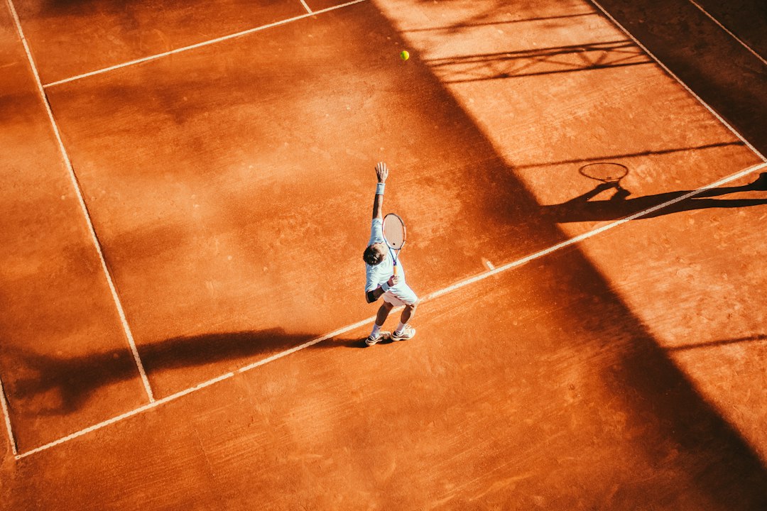 Tenis kortunda raketle vuruş yapan sporcu.